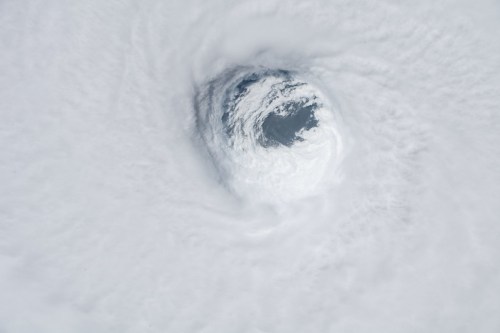 Aerial view of a swirling storm cloud formation, revealing a circular eye in the center.