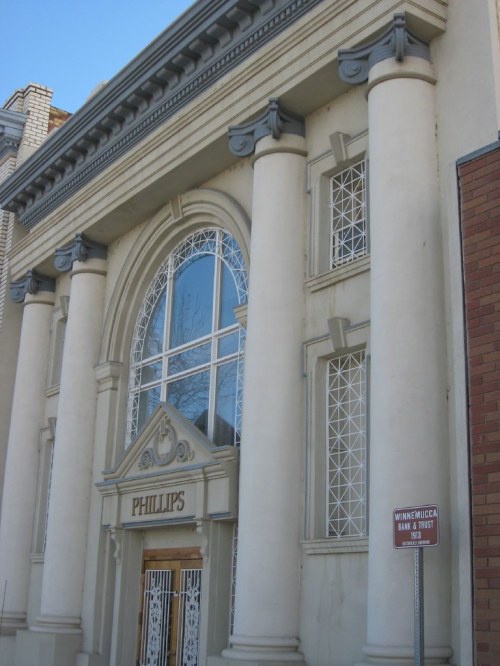 Historic building with large columns and decorative windows, featuring a sign that reads "Phillips."