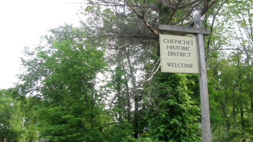 Sign for Chepachet Historic District surrounded by lush greenery, welcoming visitors to the area.