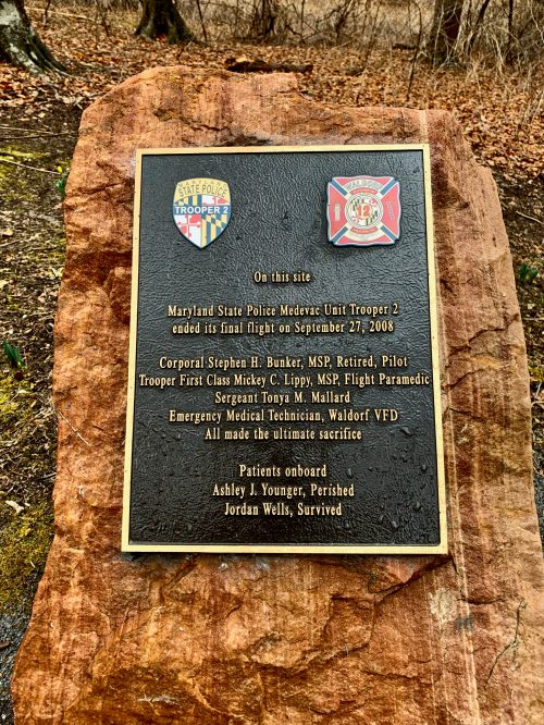 Plaque commemorating the site of a helicopter crash, honoring fallen officers and survivors from the Maryland State Police.