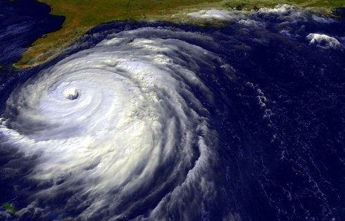 Satellite image of a powerful hurricane swirling over the ocean, with a clear eye and surrounding cloud formations.