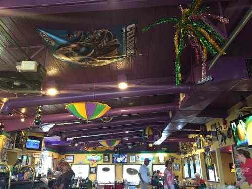 Colorful restaurant interior with purple walls, festive decorations, and patrons enjoying their meals.