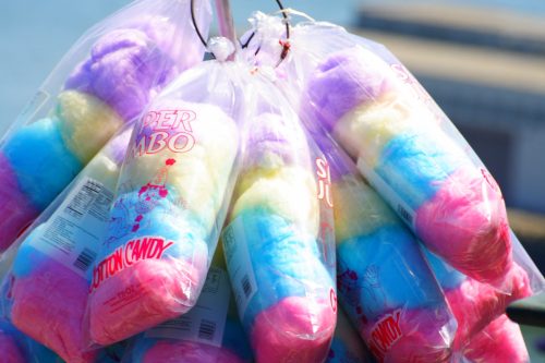 Bags of colorful cotton candy in shades of pink, blue, and yellow hanging together.