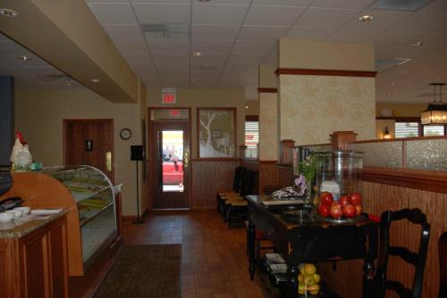 Interior of a cozy restaurant featuring wooden decor, a display case, and a view of the entrance.