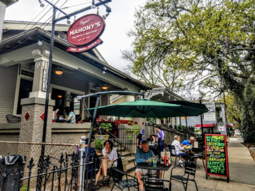 A cozy seafood restaurant with outdoor seating, featuring a sign for Mahony's and a chalkboard menu.