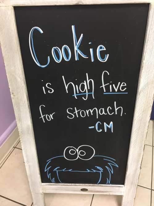 A chalkboard sign reads, "Cookie is high five for stomach." with a cartoon monster illustration at the bottom.