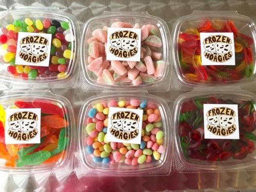 Colorful assorted candies in clear containers, labeled "Frozen Hoagies," arranged in two rows.