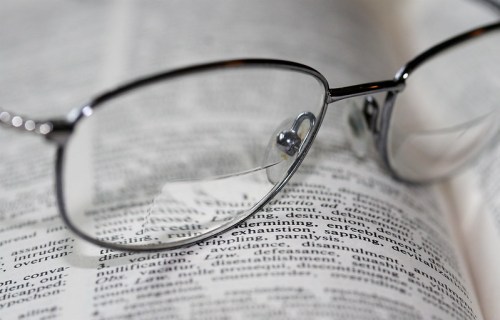 A pair of silver-framed glasses resting on an open dictionary page.