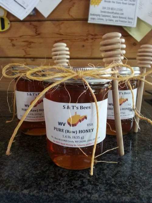 Three jars of pure raw honey with wooden dipper, labeled "S & T's Bees, WV, USA."