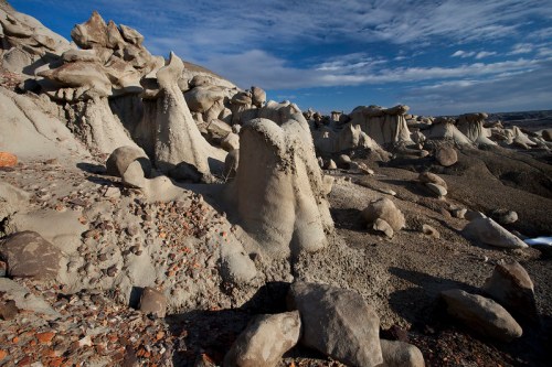 Bizarre rock formations and boulders under a blue sky, showcasing unique geological features in a rugged landscape.