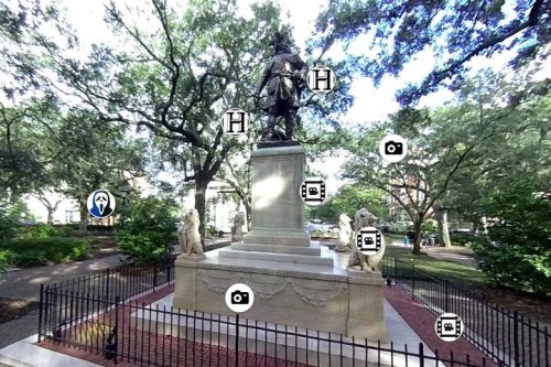 Statue surrounded by trees and lions, with icons indicating points of interest and photo opportunities nearby.