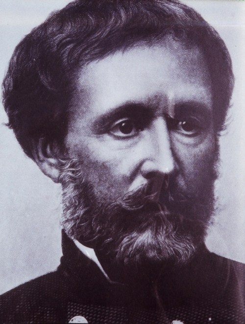 Black and white portrait of a man with a beard, wearing a military-style uniform.