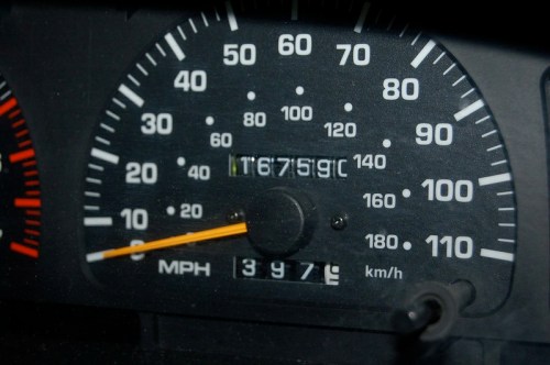 Close-up of a car's speedometer showing 67,596 miles and a speed of 20 MPH.