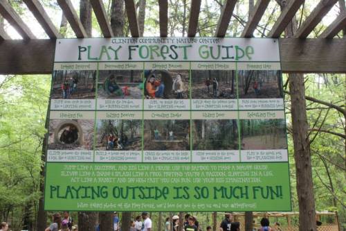 Sign at Clinton Community Nature Center with activities for kids in a play forest, encouraging outdoor exploration and imagination.