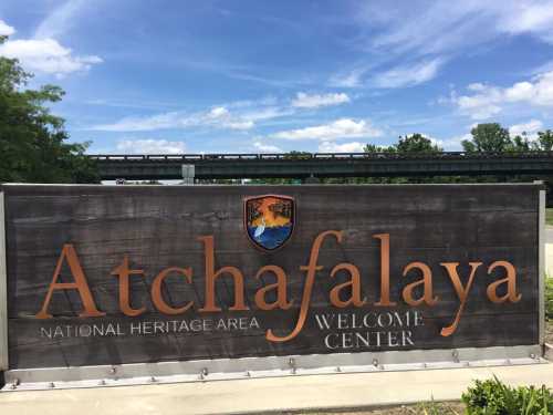 Sign for Atchafalaya National Heritage Area Welcome Center, featuring a logo and blue sky in the background.