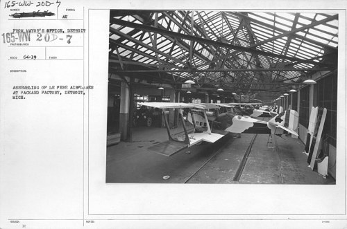 Black and white photo of aircraft assembly at Packard Factory, Detroit, showcasing multiple planes in a large industrial space.
