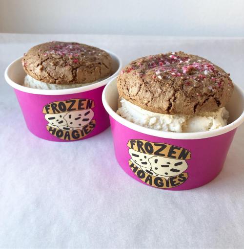 Two cups of ice cream topped with large cookie dough scoops, featuring a pink "Frozen Hoagies" logo.