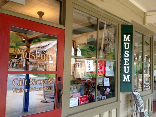 Exterior view of a museum entrance featuring a gift shop and visitor information, with a sign reading "MUSEUM."