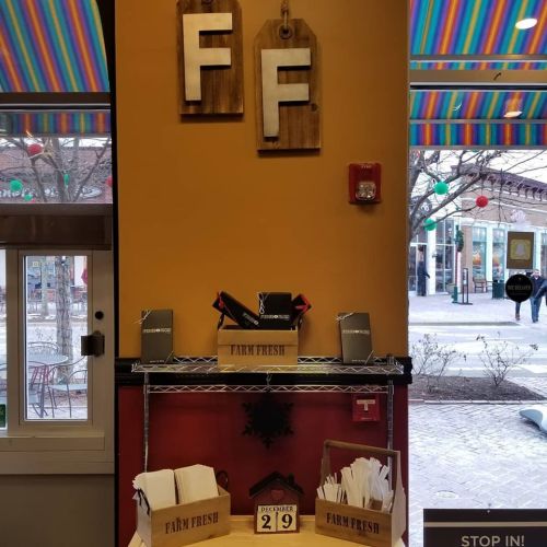 Interior view of a colorful restaurant with "FF" signage, shelves labeled "FARM FRESH," and festive decorations.