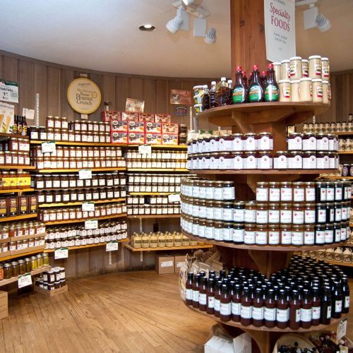 A cozy store interior filled with shelves of various jars, bottles, and condiments, showcasing specialty foods.