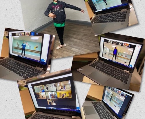 A child in a dance pose stands next to a laptop displaying a virtual dance class with multiple participants.