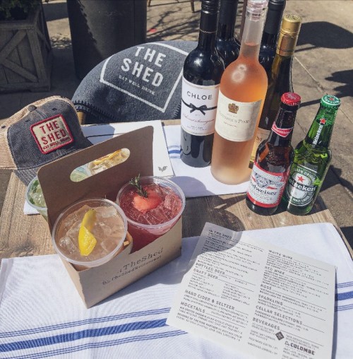 A selection of drinks including cocktails, wine, and beer, with a menu and a branded hat in the background.