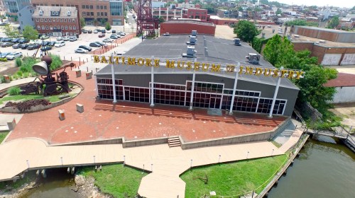 Aerial view of the Baltimore Museum of Industry, featuring a modern building and surrounding outdoor area by the water.