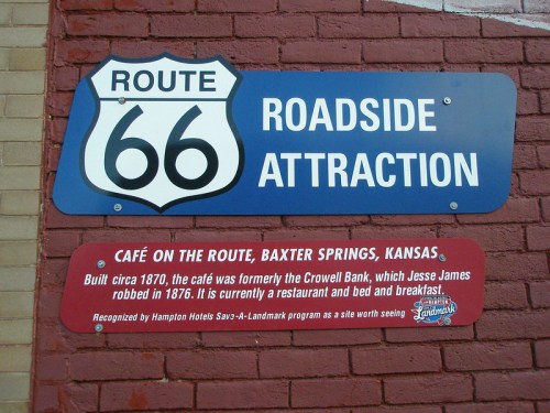 Sign for Route 66 roadside attraction, featuring "Café on the Route" in Baxter Springs, Kansas, with historical details.