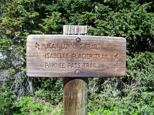 Wooden trail sign indicating Jean Lunning Trail, Isabelle Glacier Trail, and Pawnee Pass Trail directions.