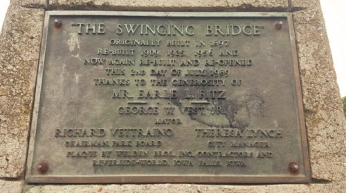 Plaque commemorating the Swinging Bridge, built in 1897, with details of its renovations and contributors.