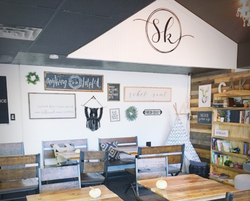 Cozy interior of a café with wooden tables, decorative signs, and a welcoming atmosphere.
