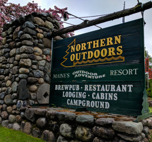 Sign for Northern Outdoors Resort in Maine, featuring amenities like a brewpub, restaurant, lodging, cabins, and campground.