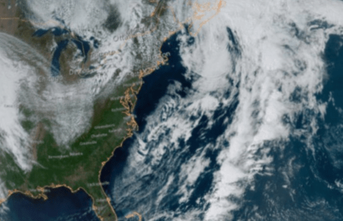 Satellite image showing the East Coast of the U.S. with clouds and ocean patterns visible.