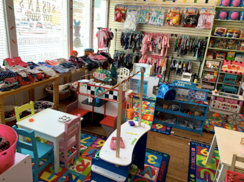 A colorful children's toy shop filled with clothes, toys, and play areas for kids.