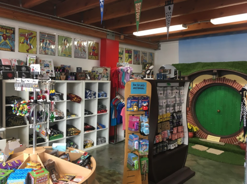 A colorful store interior featuring merchandise, shelves of clothing, and a whimsical green door backdrop.