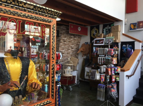 A colorful shop interior featuring a Zoltar fortune teller machine and various merchandise displays.
