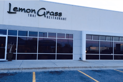 Exterior of Lemon Grass Thai Restaurant, featuring large windows and a modern facade in a commercial area.