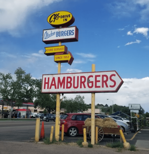 Sign for Cy's Drive-In featuring "Alaskan Burgers" and "Hamburgers," with a vintage design and curb service since 1953.