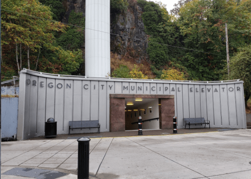 Entrance to the Oregon City Municipal Elevator, featuring a modern design and surrounded by greenery.