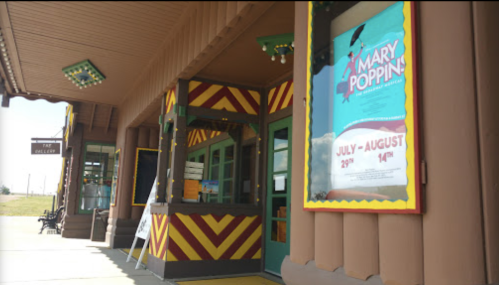 Colorful theater entrance with a poster for "Mary Poppins" and decorative wooden architecture.