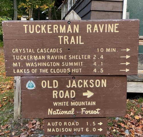 Wooden trail sign with directions to Tuckerman Ravine, Crystal Cascades, and Old Jackson Road in White Mountain National Forest.