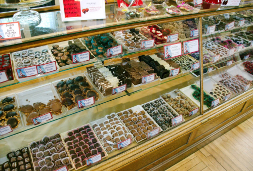 A display case filled with various chocolates and confections, neatly arranged in rows with labels.