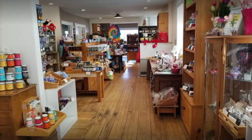 A cozy shop interior filled with colorful products, wooden shelves, and a warm, inviting atmosphere.