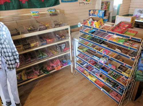 A colorful display of various candies and snacks in a store, with shelves filled with treats on both sides.