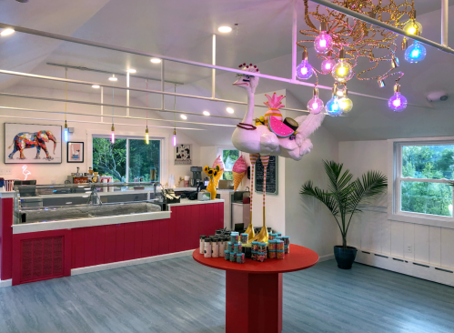 Brightly colored ice cream shop interior featuring a large ostrich statue and vibrant lighting.