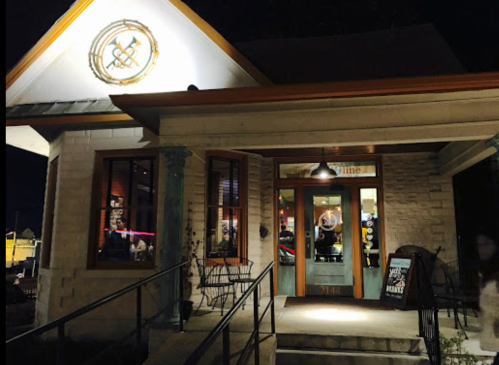 A cozy restaurant exterior at night, featuring a welcoming entrance and outdoor seating.