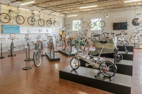 A bicycle exhibit featuring various styles of bikes displayed on pedestals in a well-lit gallery.