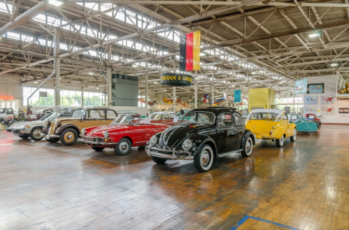 A vintage car museum featuring various classic cars in a spacious, well-lit exhibition area.