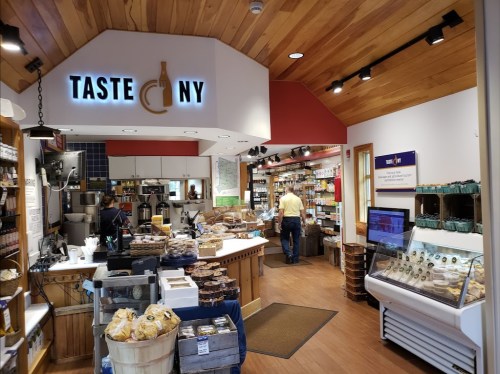 Interior of a cozy market with wooden accents, showcasing local products and a display of baked goods.