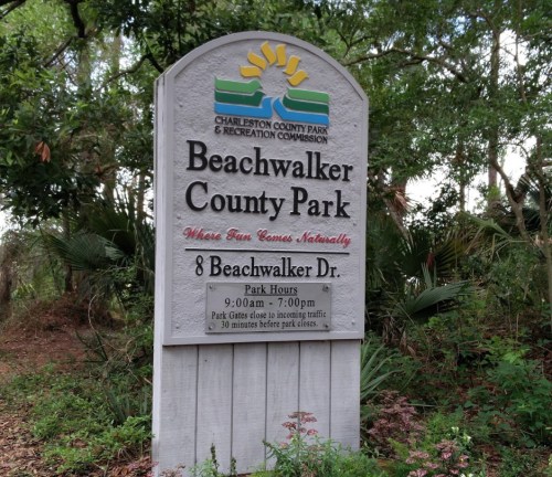Sign for Beachwalker County Park, listing park hours and location at 8 Beachwalker Dr. Surrounded by greenery.